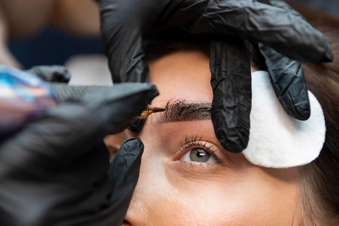 Young woman getting beauty treatment her eyebrows