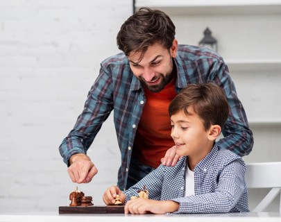 Father teaching son play chess
