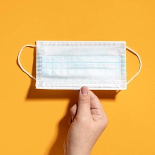 Flat lay hand holding medical mask