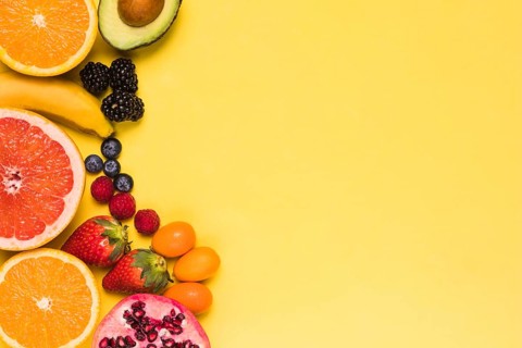 Sliced fruits berries yellow background