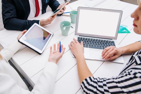 Colleagues with devices working desk