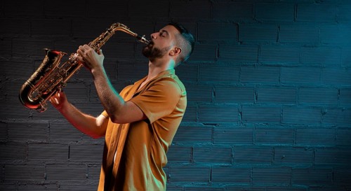 Male musician playing saxophone spotlight with copy space