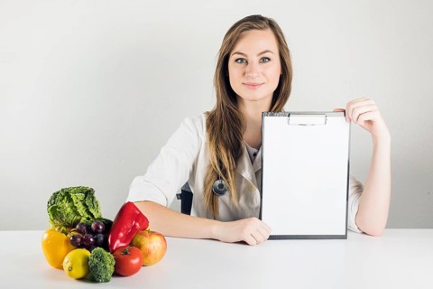 Female dietician holding blank clipboard