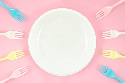 Colorful plastic dishes pink background