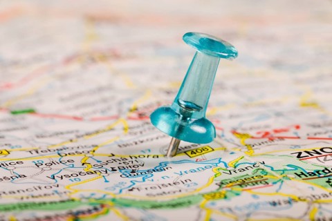 Turquoise colored pushpin stucked world map