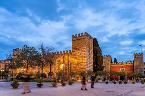 Tower and walls of the Alcazar Royal Palace at dusk