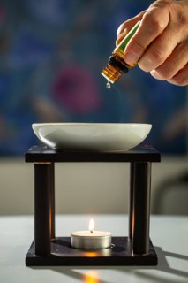 One person drips essential fragrance oil into a bowl