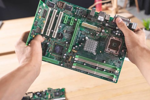 Close up it male technician holding computer mainboard
