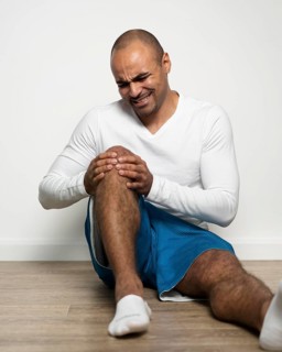 Front view man suffering from knee pain