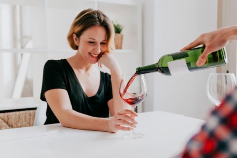 Hand pouring wine girlfriend