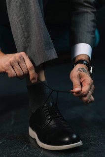 Low section businessman s hand tying shoelace