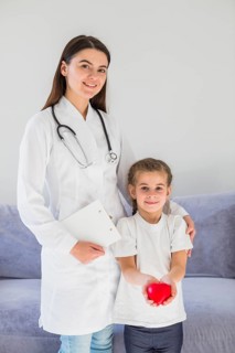 Blonde girl holding heart with doctor