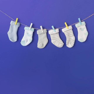 Different type baby s sock hang clothesline against blue backdrop
