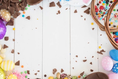 Easter chocolate eggs with candies wooden table