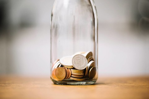 Coins glass bottle wooden surface