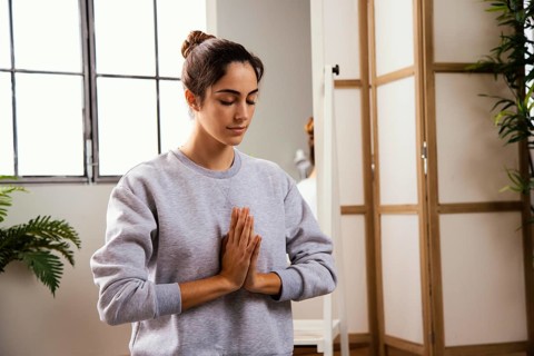 Front view young woman doing yoga home
