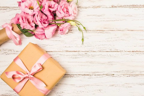 Wrapped pink eustoma flower gift box white old table