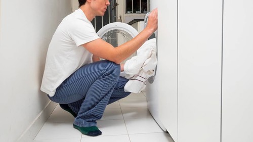 Man putting clothes washing machine
