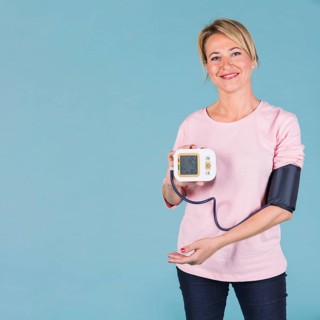 Smiling woman showing results blood pressure electric tonometer screen
