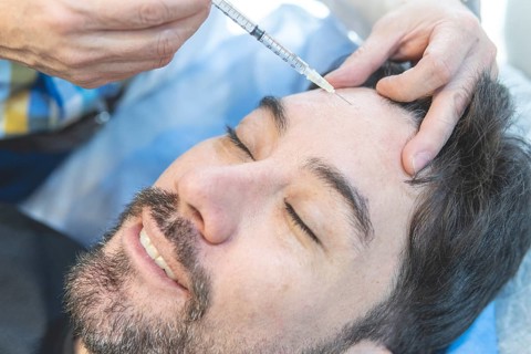 Latin man getting filler injections in aesthetic medical clinic