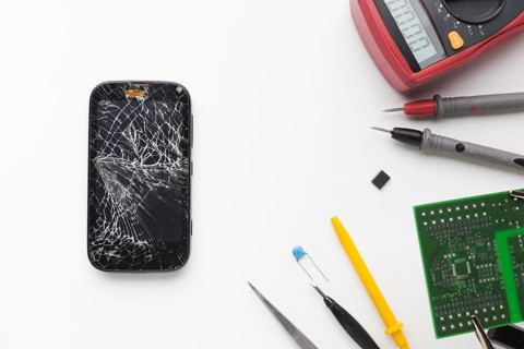 Top view broken phone with electronic tools