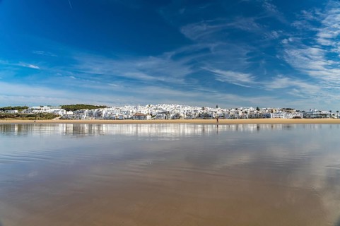 The town view of Conil reflected on the beach Playa De Los Bateles
