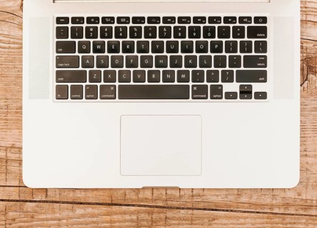 Topview laptop keyboard wooden background