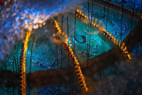 The colourful lights of the Mainfest are reflected in a puddle. The Mainfest on the Mainkai