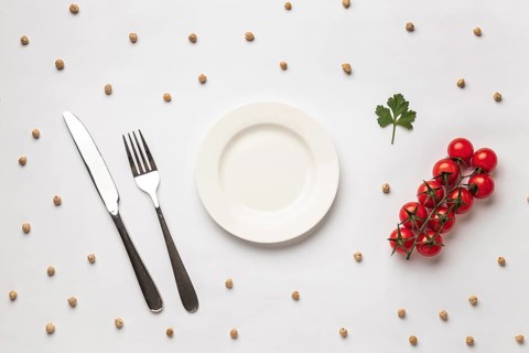 Flat lay fresh tomatoes with plate cutlery