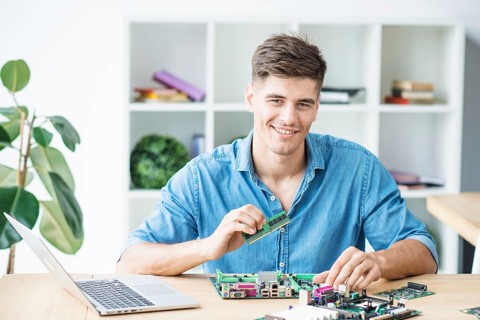 Smiling young male it technician with hardware equipment s