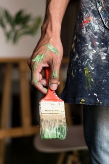 Hand holding stained brush