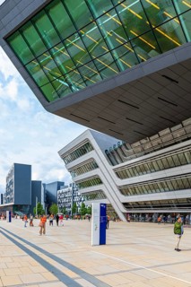 Students in front of modern building on the campus of the University of Economics WU