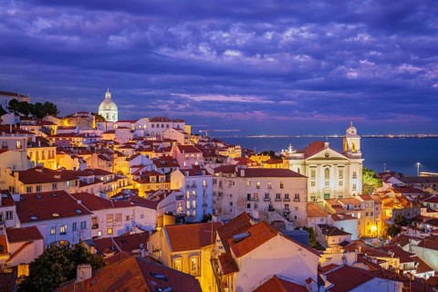 View of Lisbon famous view from Miradouro de Santa Luzia tourist viewpoint over Alfama old city district at night. Lisbon