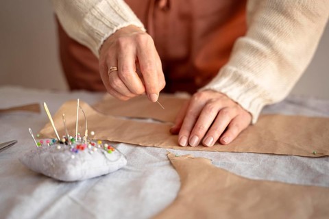 Tailor woman using needle thread sew