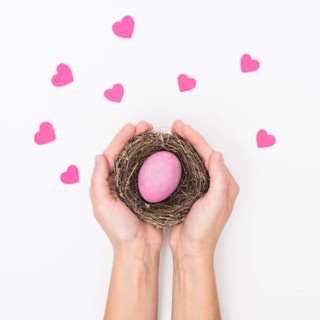Person holding nest with bright easter egg