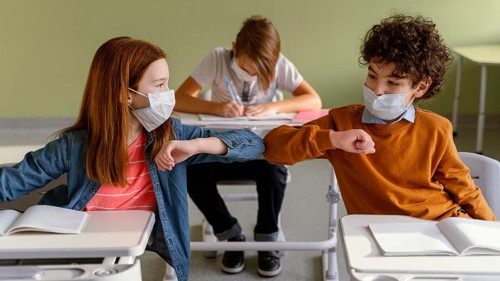 Front view children with medical masks doing elbow salute class