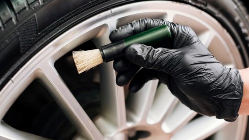 Man cleaning car rims