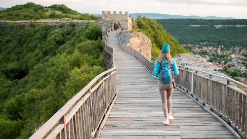 Back view traveller walking down bridge