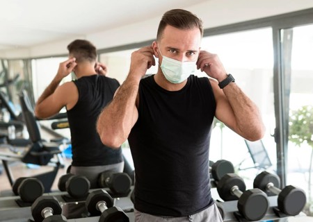 Man putting medical mask gym