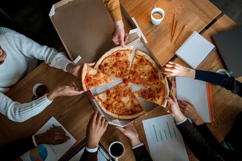 Top view colleagues having pizza during office meeting break