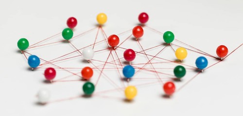 Colourful pushpins with thread route map