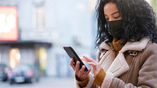 Woman with medical mask checking her phone