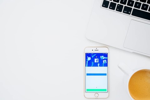 Facebook app phone with coffee laptop