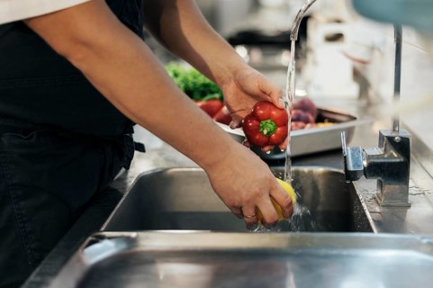 Side view male chef washing vegetables