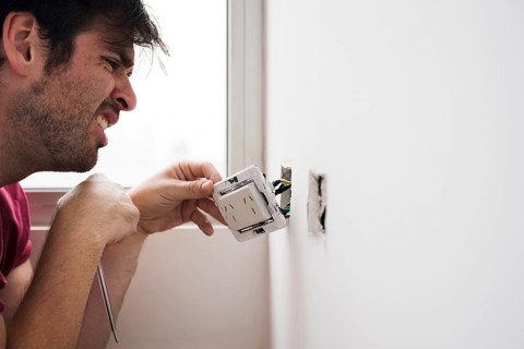 Close up male electrician working home