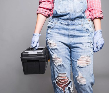 Woman overall holding tool box