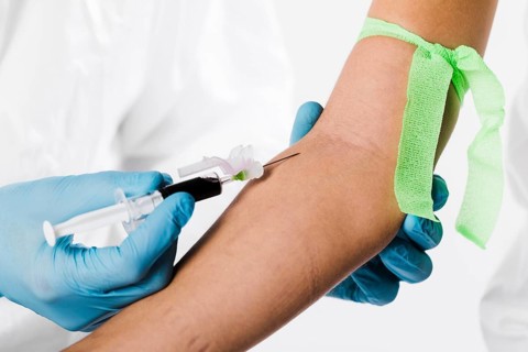 Doctor taking blood sample from sick person