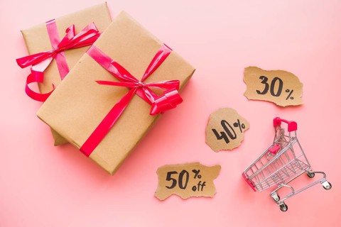 Gift boxes with red bows near shopping trolley