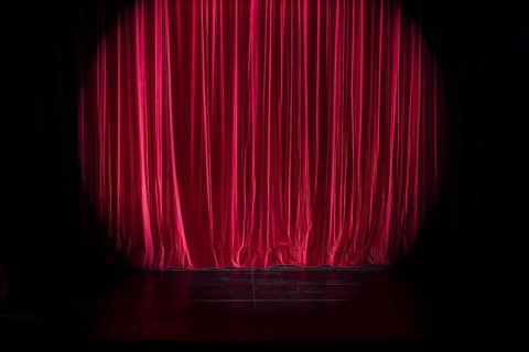Empty stage with light spot on red curtain