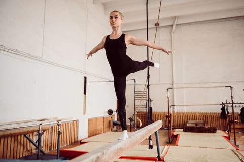 Front view blonde woman training balance beam
